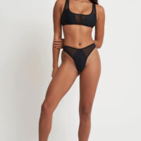 a model showing the front of a black bikini with mesh details