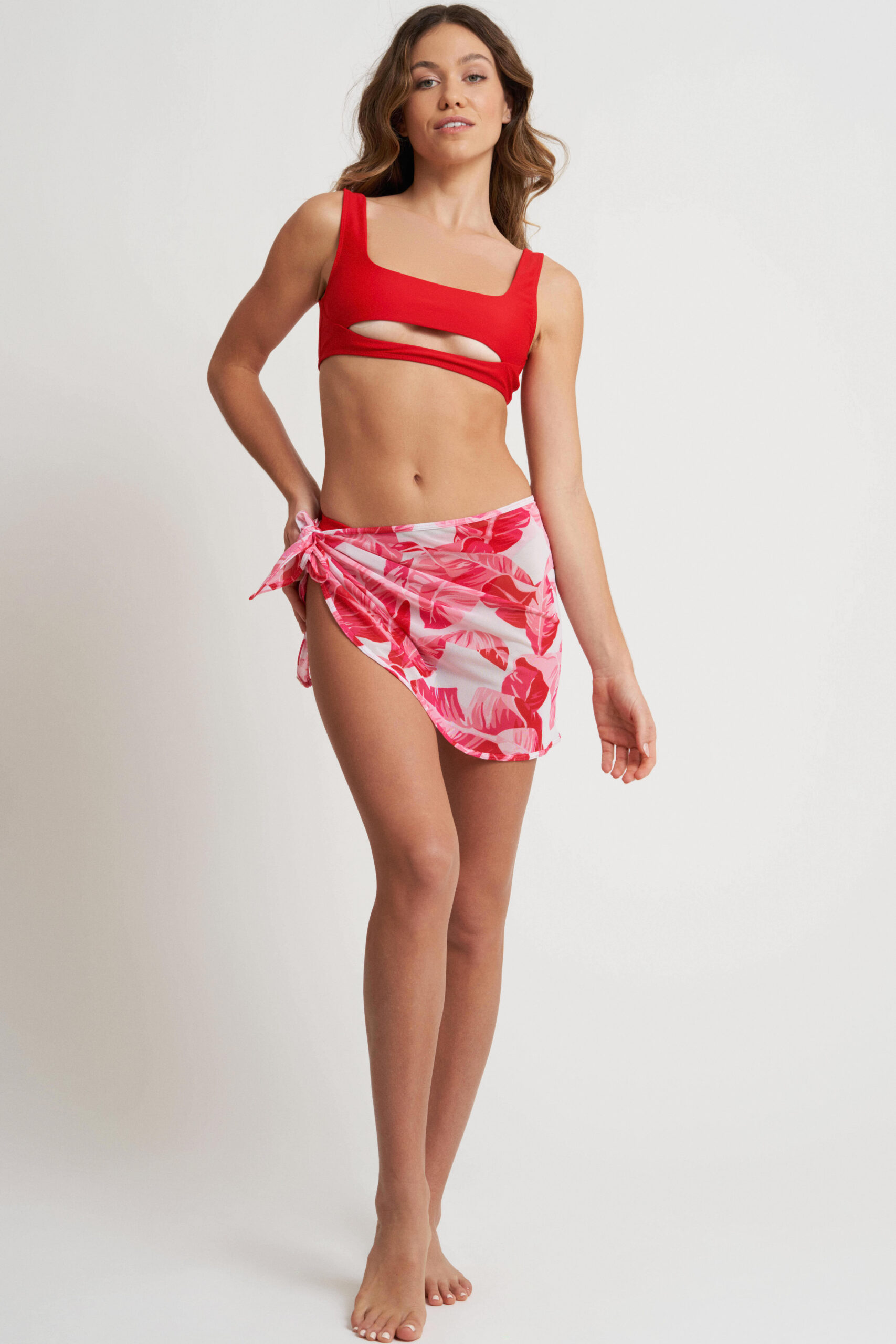 model in a red floral sarong and a red bikini top