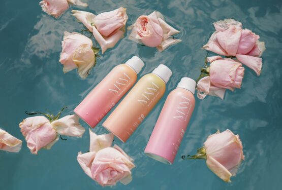 suncare products floating in a pool with roses